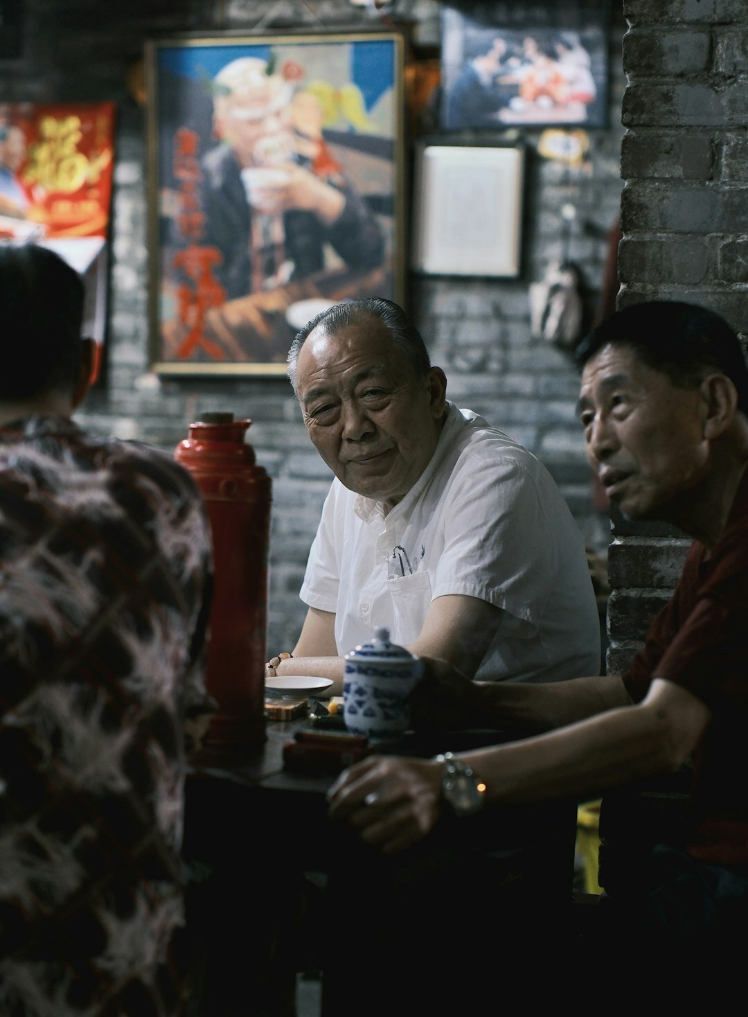 Elderly people sitting around a table enjoying tea and conversation